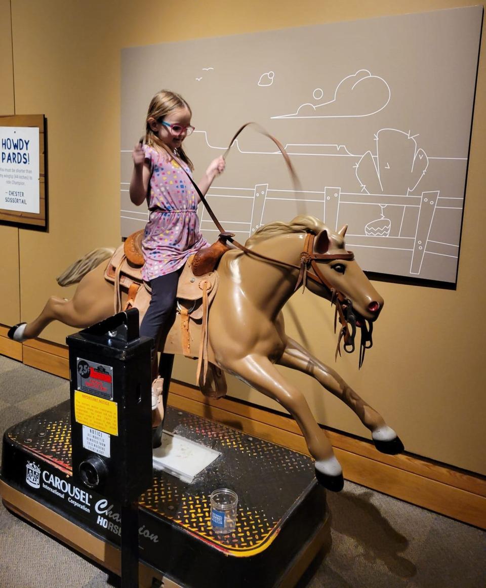 Kyla McDonnell, 6-year-old daughter of The Oklahoman Features Writer Brandy McDonnell, rides "Champion," a 1990s coin-operated horse, in the exhibit "Playing Cowboy" at the National Cowboy & Western Heritage Museum.