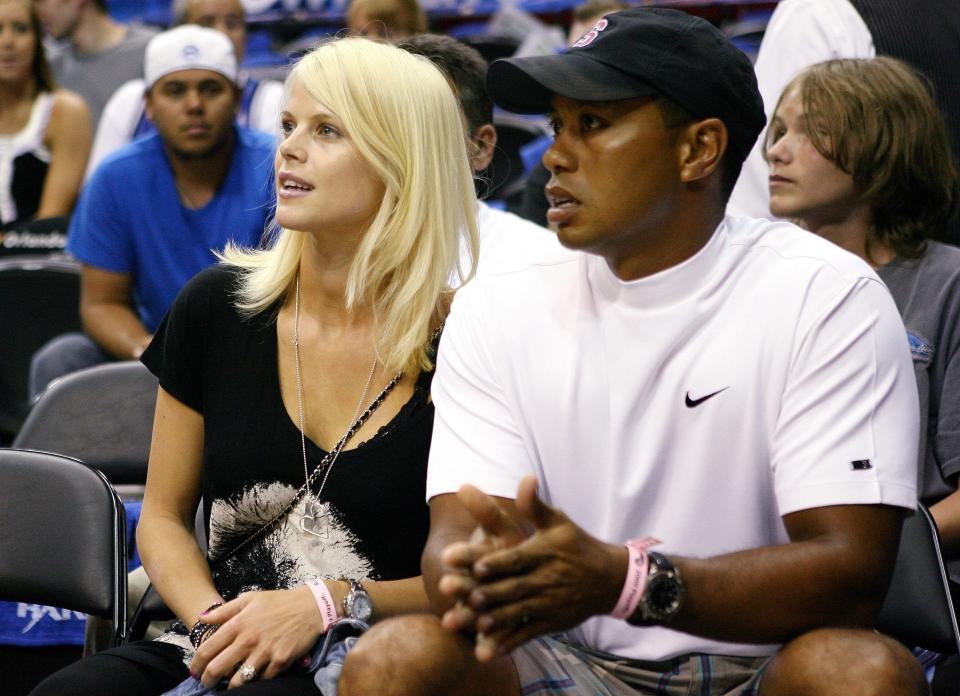 Golfer Tiger Woods sits courtside with his wife Elin during Game Four of the 2009 NBA Finals between the Los Angeles Lakers and the Orlando Magic at Amway Arena on June 11, 2009 in Orlando, Florida. The Lakers won 99-91 in overtime and lead the series 3-1.(Photo by Elsa/Getty Images)