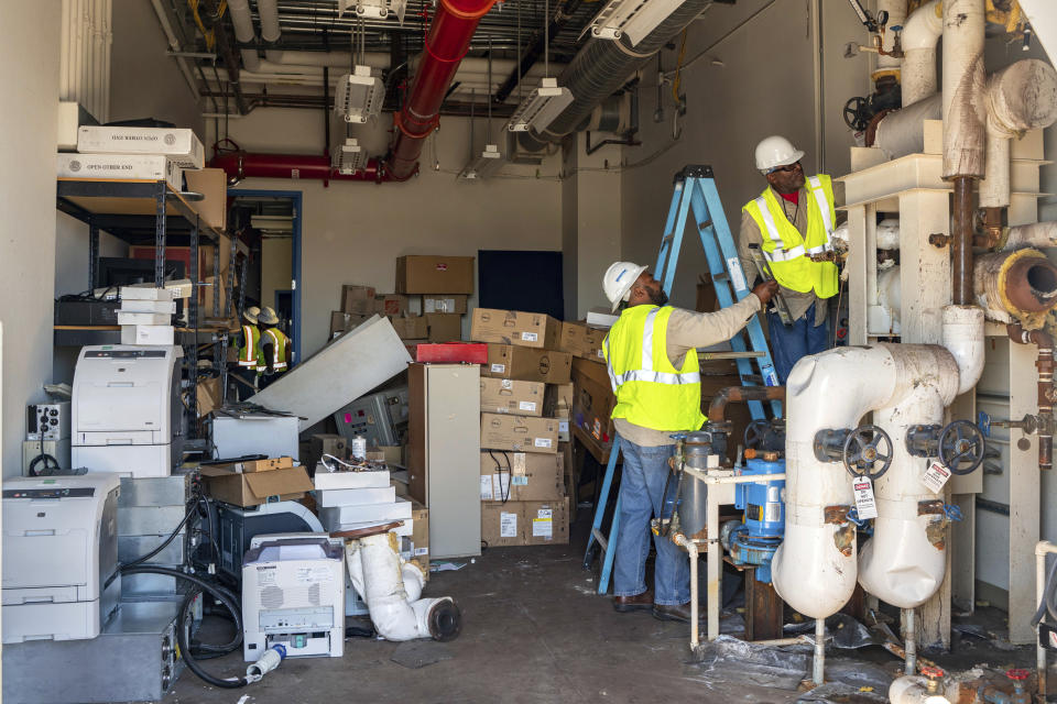 In this July 10, 2019 photo provided by the U.S. Navy, Department of Defense employees Matenis Bell and Andre Ledford, assigned to Naval Air Weapons Station China Lake, Calif., conduct building repairs after multiple earthquakes occurred July 4 and 5 in Kern County, Calif. The base sustained heavy earthquake damage that experts estimate will cost over $5 billion to repair. (Mass Communication Specialist 1st Class Arthurgwain L. Marquez/U.S. Navy via AP)