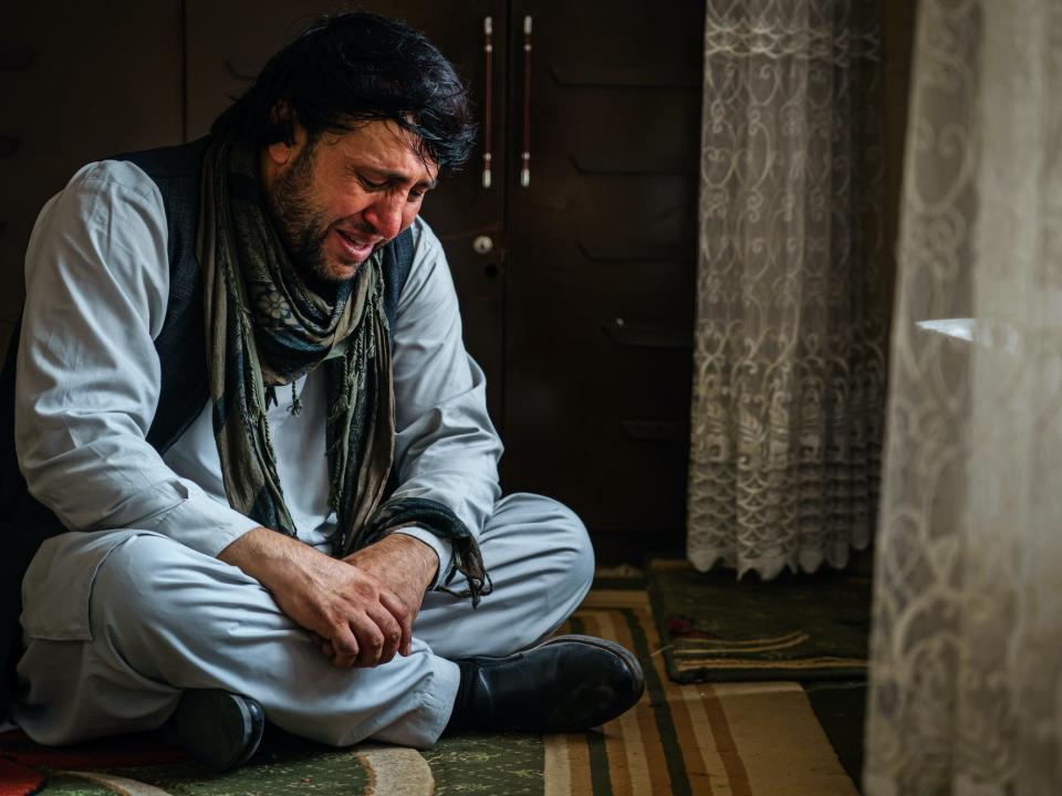 An Afghan man who lost family due to US drone strikes weeps.