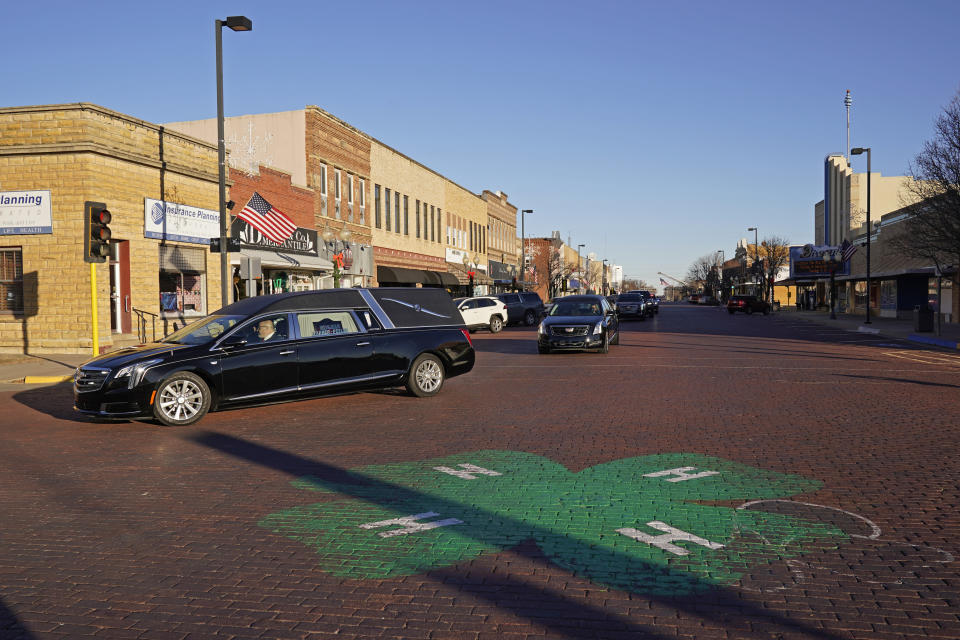 A hearse carrying the casket holding former Sen. Bob Dole, R-Kan., drives down Main Street on the way to a memorial service, Saturday, Dec. 11, 2021, in Russell, Kan. (AP Photo/Charlie Riedel)