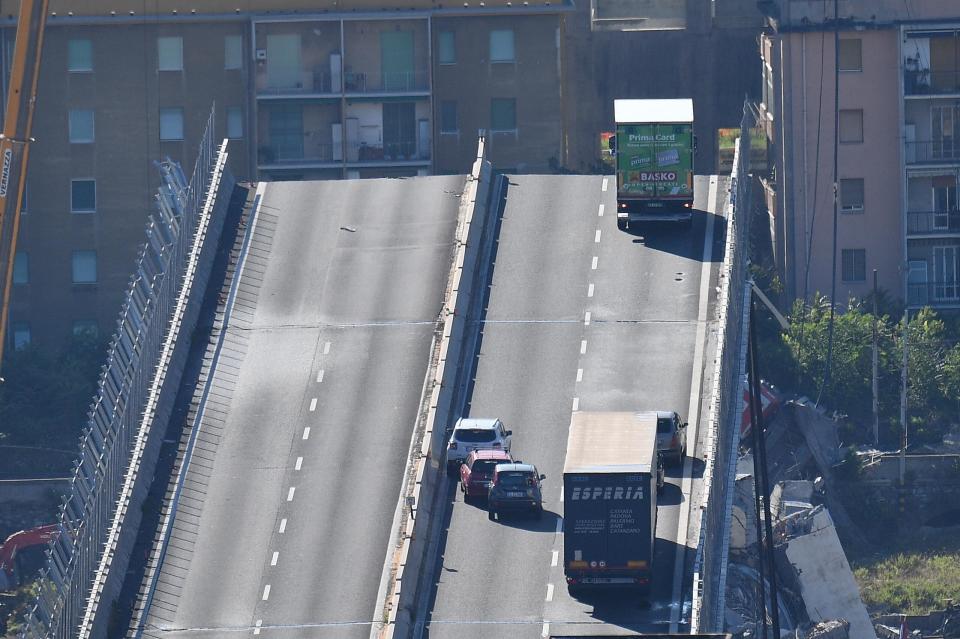 A truck is blocked at the end of the collapsed Morandi highway bridge in Genoa, northern Italy, Wednesday, Aug. 15, 2018. A bridge on a main highway linking Italy with France collapsed in the Italian port city of Genoa during a sudden, violent storm, sending vehicles plunging 90 meters (nearly 300 feet) into a heap of rubble below. (Luca Zennaro/ANSA via AP)