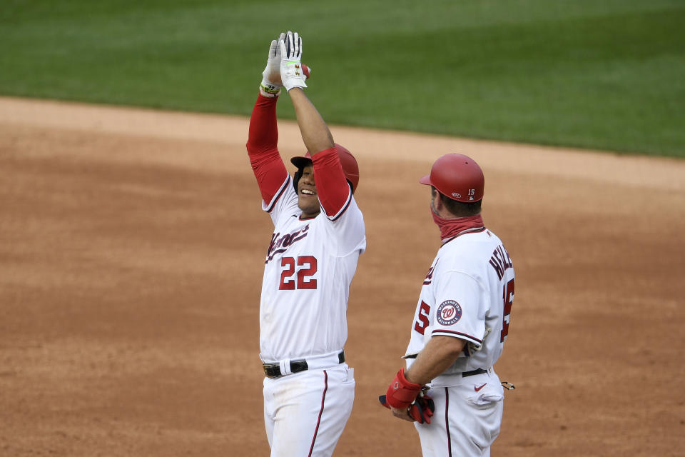 Washington Nationals' Juan Soto (22) reacts at first after his single during the second inning of a baseball game against the New York Mets, Sunday, Sept. 27, 2020, in Washington. Also seen is Nationals first base coach Bob Henley at right. The Nationals won 15-5. (AP Photo/Nick Wass)