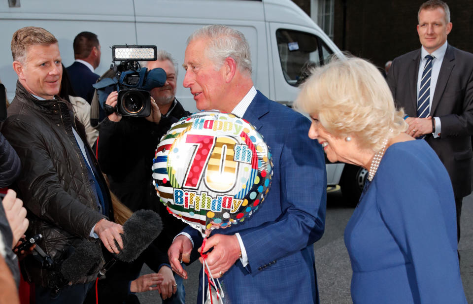 LONDON, UNITED KINGDOM - NOVEMBER 14: (EMBARGOED FOR PUBLICATION IN UK NEWSPAPERS UNTIL 24 HOURS AFTER CREATE DATE AND TIME) Camilla, Duchess of Cornwall looks on as Prince Charles, Prince of Wales receives a birthday present and helium balloon as they attends an Age UK Tea, celebrating 70 inspirational people marking their 70th birthday this year at Spencer House on November 14, 2018 in London, England. The Prince of Wales celebrates his 70th birthday today, he was born on November 14 1948 at Buckingham Palace. (Photo by Max Mumby/Indigo/Getty Images)