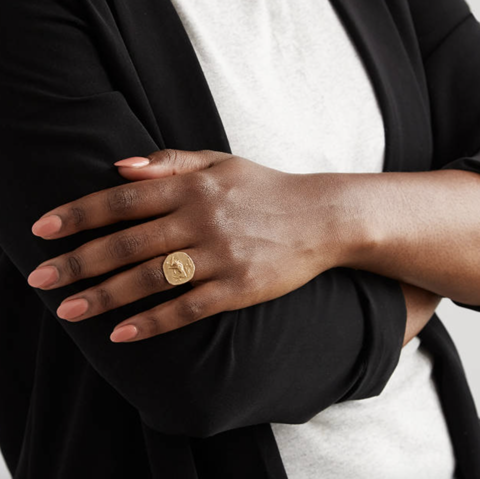 gold circle Zodiac Rings on black woman hand