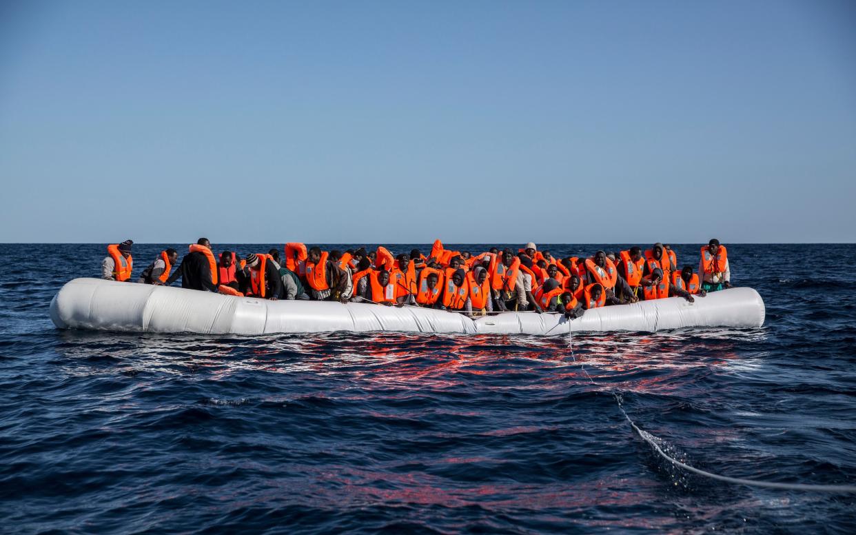 Migrants crowd a dinghy as they are rescued from the Mediterranean sea near Libya - AP