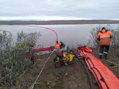 In this handout photo provided by the Russian Marine Rescue Service, rescuers work to prevent the spread of an oil spill outside Norilsk, 2,900 kilometers (1,800 miles) northeast of Moscow, Russia, on Tuesday, June 2, 2020. Russian President Vladimir Putin has declared a state of emergency in a region of Siberia after an estimated 20,000 tons of diesel fuel spilled from a power plant storage facility and fouled waterways.(Russian Marine Rescue Service via AP)
