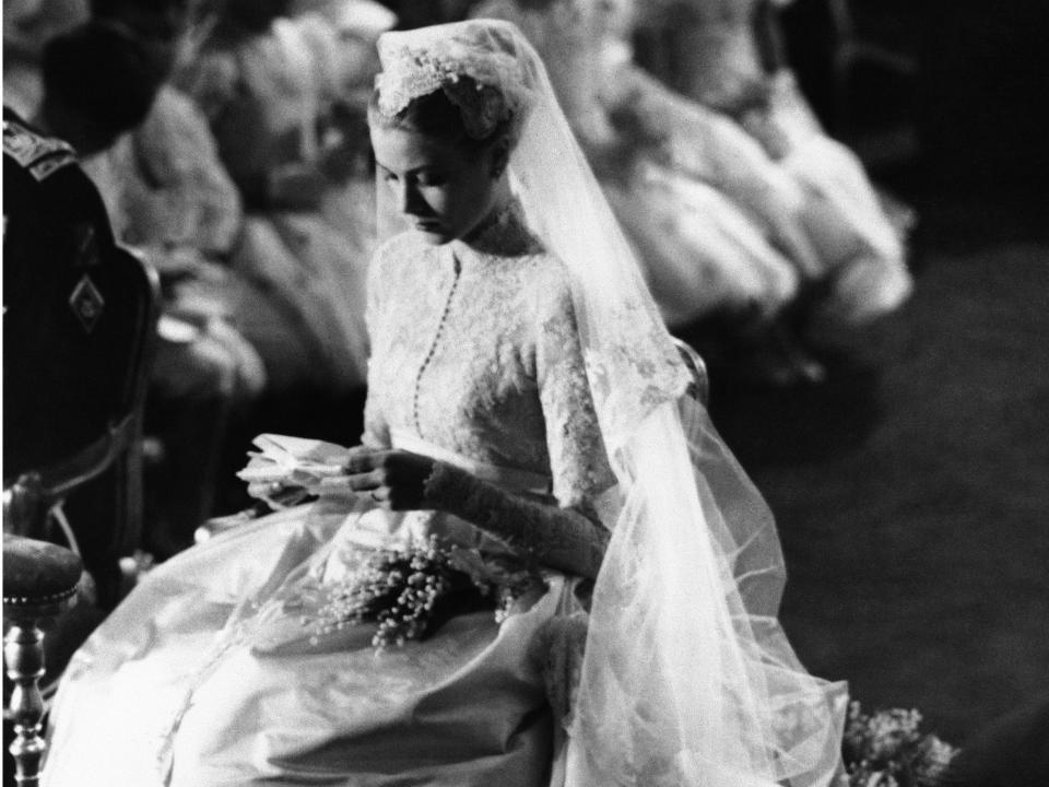 grace kelly kneeling in elaborate wedding dress