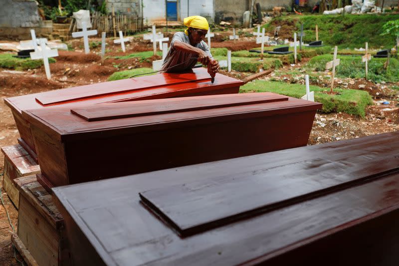 Suherman, a 45-year-old coffin maker, prepares coffins ordered to be donated for the coronavirus disease (COVID-19) victims at a workshop inside a funeral complex in Jakarta