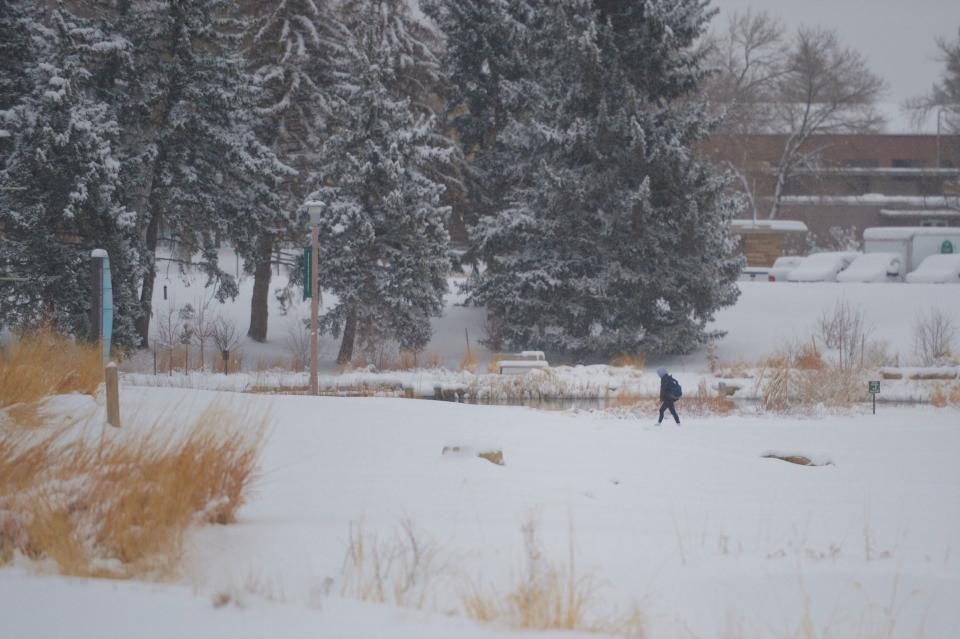 A person walks on the Colorado State University campus on Monday. CSU canceled classes due to the storm, but Poudre School District and Thompson School District did not.