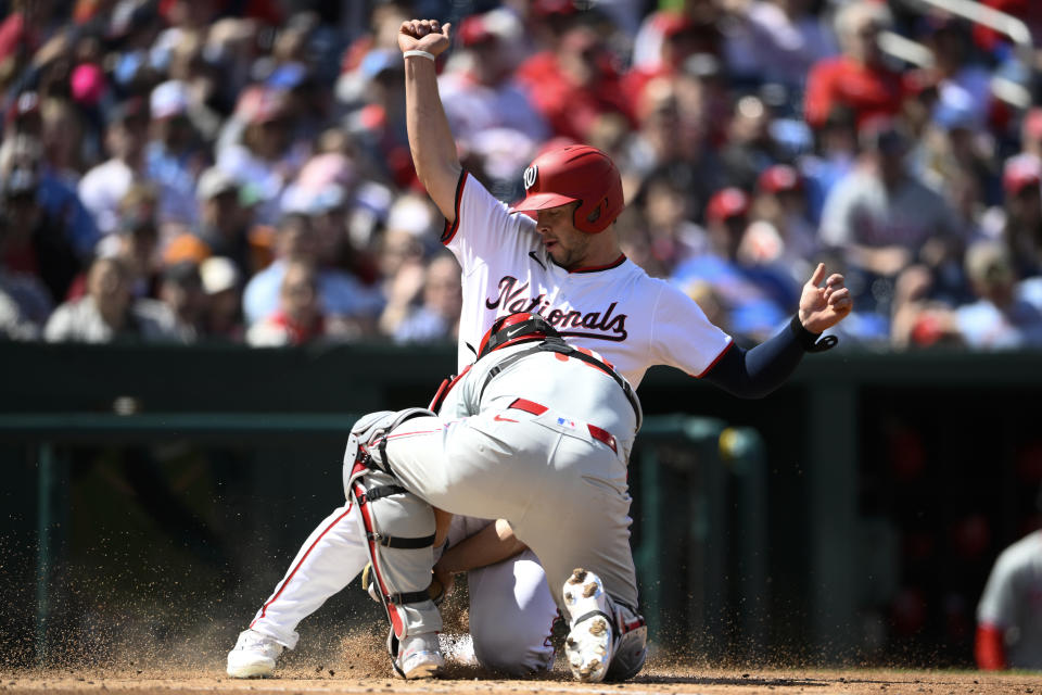 Washington Nationals' Riley Adams, back, is out at home against Philadelphia Phillies catcher J.T. Realmuto, front, during the second inning of a baseball game, Sunday, April 7, 2024, in Washington. (AP Photo/Nick Wass)