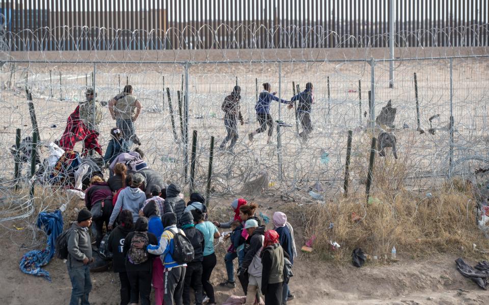 Migrants trying to surrender to the U.S. Border Patrol in El Paso broke through razor wire barriers set up along the Rio Grande by the Texas National Guard.