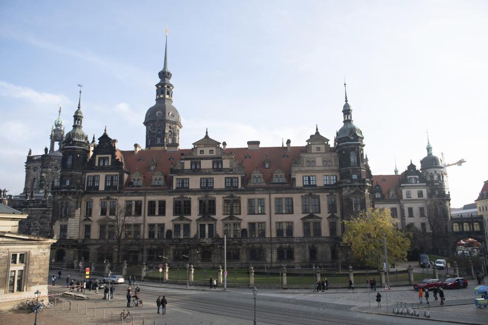 People stand in front of the Residenzschloss, Residence Palace, building with the Green Vault in Dresden Monday, Nov. 25, 2019. Authorities in Germany say thieves have carried out a brazen heist at Dresden’s Green Vault, one of the world’s oldest museum containing priceless treasures from around the world. (Sebastian Kahnert/dpa via AP)