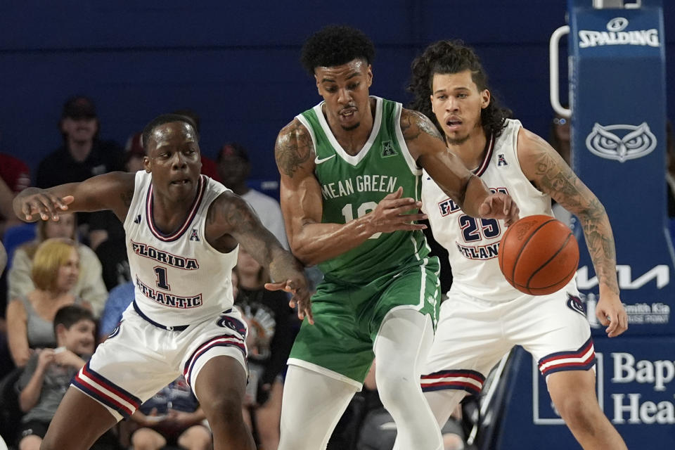 Florida Atlantic guard Johnell Davis (1) swats the ball away from North Texas forward Robert Allen (10) as forward Tre Carroll (25) looks on during the first half of an NCAA college basketball game, Sunday, Jan. 28, 2024, in Boca Raton, Fla. (AP Photo/Wilfredo Lee)