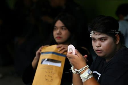 A transgender puts on make up as she waits to speak to officers during an army draft held at a school in Klong Toey, the dockside slum area in Bangkok, Thailand, April 5, 2017. REUTERS/Athit Perawongmetha