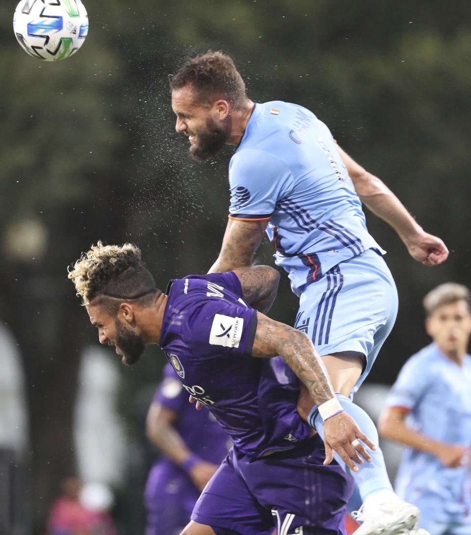 New York City FC's Maxime Chanot, top, heads the ball over Orlando City's Dom Dwyer during an MLS is Back tournament soccer match, Tuesday, July 14, 2020, in Lake Buena Vista, Fla. (Stephen M. Dowell/Orlando Sentinel via AP)