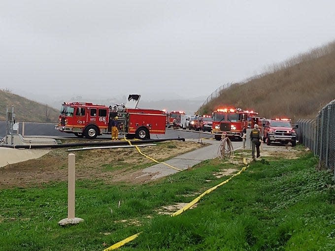 Fire and law enforcement officials surround near the scene of an aircraft crash in Calabasas, California on Jan. 26, 2020.