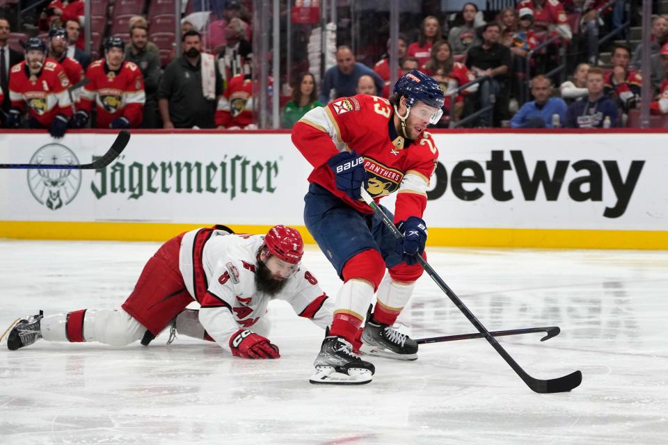 Florida Panthers center Carter Verhaeghe (23) comes in for a shot against Carolina Hurricanes defenseman Brent Burns (8) during the second period of Game 4 of the NHL hockey Stanley Cup Eastern Conference finals, Wednesday, May 24, 2023, in Sunrise, Fla. .  (AP Photo/Wilfredo Lee)