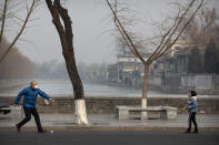 A man and girl wear face masks as they play badminton near the closed Forbidden City in Beijing, Monday, Jan. 27, 2020. China on Monday expanded sweeping efforts to contain a viral disease by postponing the end of this week's Lunar New Year holiday to keep the public at home and avoid spreading infection. (AP Photo/Mark Schiefelbein)