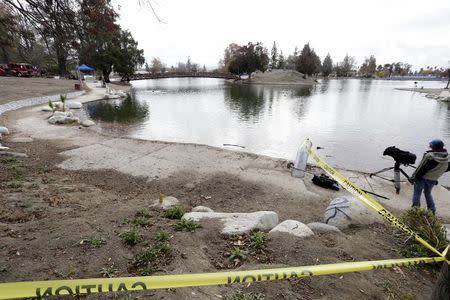 Police barrier tape is seen as a search is carried out of Seccombe Lake Park after a shooting earlier this month in San Bernardino, California December 11, 2015. REUTERS/Jonathan Alcorn