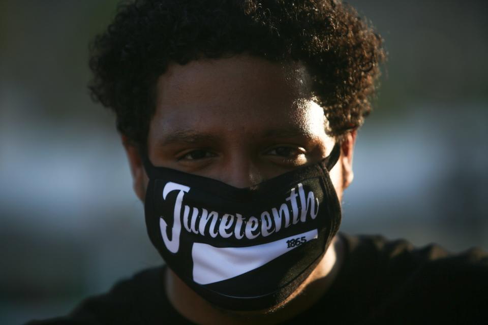 Dom Moore wears a Juneteenth mask at an event marking the day slaves were emancipated in the United States. Young Justice Advocates organized the event at Frances Stevens Park in Palm Springs, Calif. on Saturday, June 20, 2020.