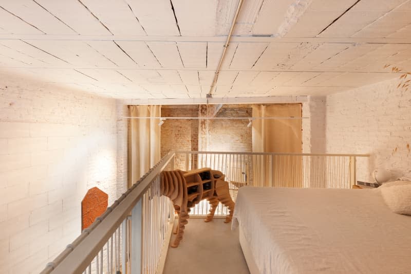 Painted white brick loft bedroom with dog