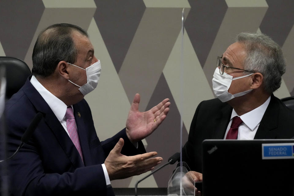 Senator Omar Aziz, left, talks with Sen Renan Calheiros, during a session by their commission investigating the government's management of the COVID-19 pandemic at the Federal Senate in Brasilia, Brazil, Tuesday, Oct. 26, 2021. (AP Photo/Eraldo Peres)