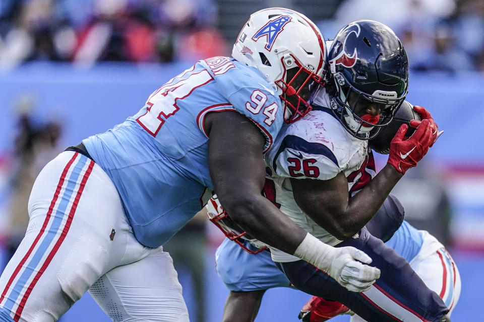Houston Texans running back Devin Singletary (26) is hit by Tennessee Titans defensive tackle Jaleel Johnson (94) during the second half of an NFL football game, Sunday, Dec. 17, 2023, in Nashville, Tenn. (AP Photo/George Walker IV)