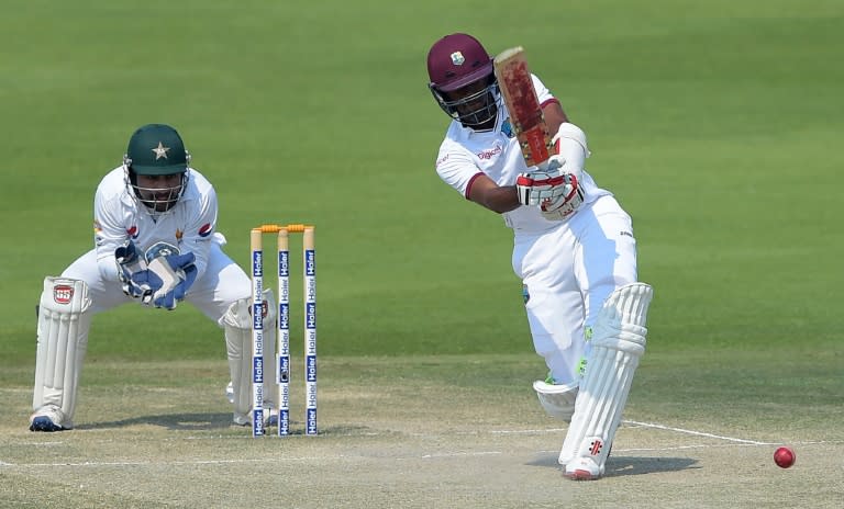 West Indies' batsman Kraigg Brathwaite (R) plays a shot as Pakistani wicketkeeper Sarfraz Ahmed looks on during the fourth day of the second Test in Abu Dhabi on October 24, 2016