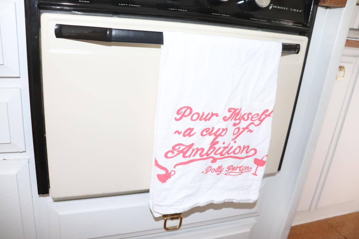 A kitchen towel that reads "Pour myself a cup of ambition"