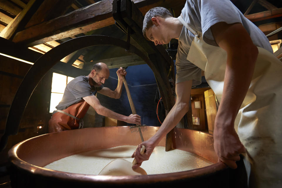 Cheese maker and farmer Jacques Murith (L) and his son Alexandre curd the milk at Le Commun mountain pasture chalet in Gruyeres, western Switzerland, July 7, 2013. During the summer grazing season, starting mid-May to mid-October, the fifth generation Murith family produceQuesero y agricultor Jacques Murith (izquierda) y su hijo Alexandre cuajan la leche en un chalet de Le Commun, en Gruyeres, Suiza. Durante la temporada de pastoreo de verano, desde mediados de mayo hasta mediados de octubre, la quinta generación de la familia Murith produce el distintivo queso Gruyere de pasto de montaña. Cada rueda de queso pesa entre 25 y 40 kilogramos y tarda un mínimo de seis meses en madurar. (REUTERS/Denis Balibouse)