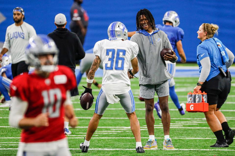 Lions wide receiver Jameson Williams, center, talks to cornerback Chase Lucas (36) during open practice at Family Fest at Ford Field on Saturday, August 6, 2022.