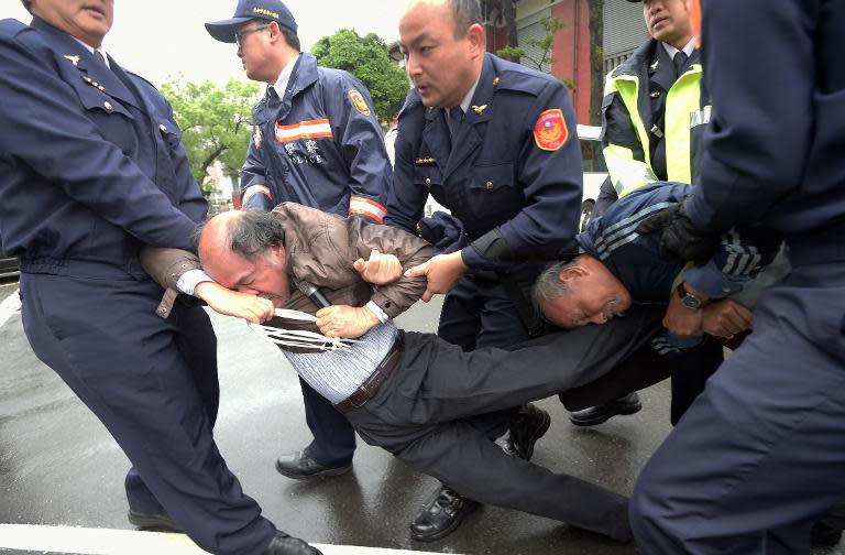 Policemen remove activists outside parliament in Taipei during a protest against China's plan to launch of a controversial new flight route over the Taiwan Strait on March 27, 2015