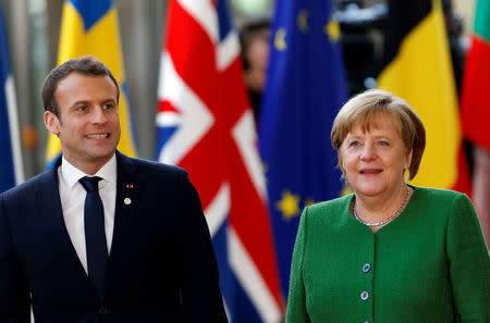 French President Emmanuel Macron and Germany's Chancellor Angela Merkel arrive at a European Union heads of state informal meeting in Brussels, Belgium, February 23, 2018. REUTERS/Francois Lenoir