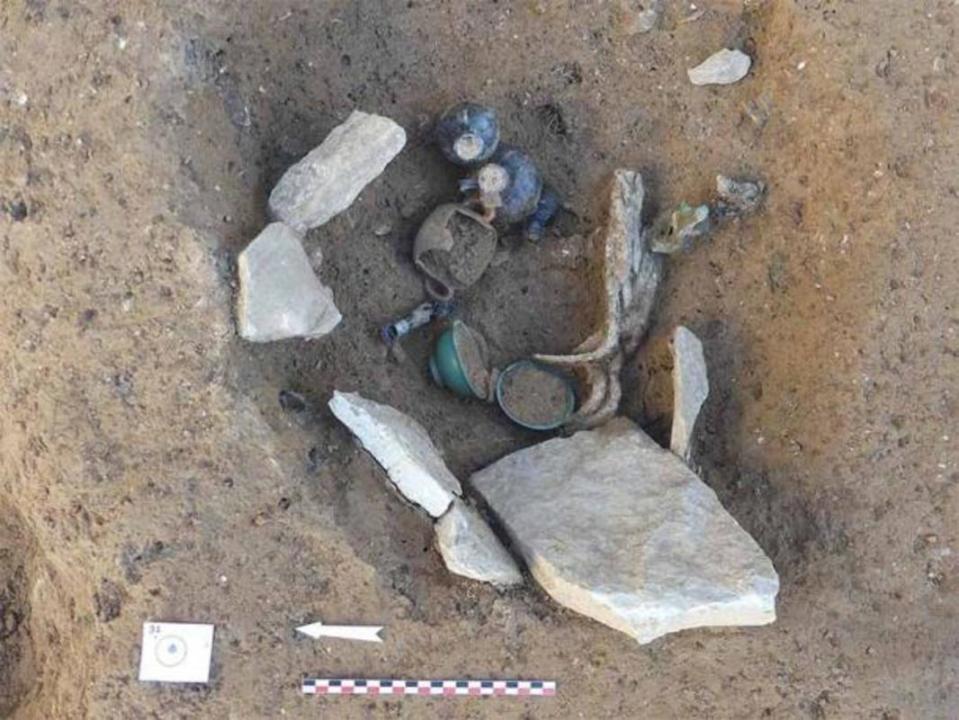 A cremation deposit with remnants of concrete slabs, burnt bone, and glassware.<p>Archaeology News / V Bel / INRAP</p>