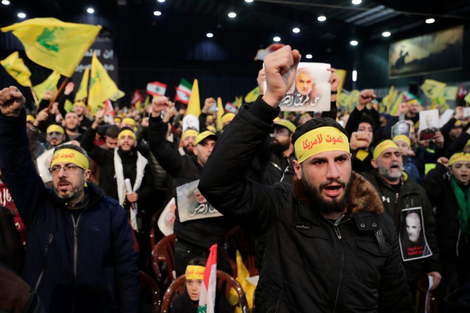 Supporters of the Shiite Hezbollah movement react with clenched fists as the movement's leader delivers a speech on a screen, in the Lebanese capital Beirut's southern suburbs on January 5, 2020. - The head of Lebanon's Shiite movement Hezbollah Hassan Nasrallah called on Iraq to free itself of the American "occupation" after top Iranian general Qasem Soleimani was killed in a US strike in Baghdad. (Photo by ANWAR AMRO / AFP) (Photo by ANWAR AMRO/AFP via Getty Images)