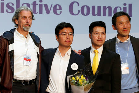 (L-R) Pro-democracy candidates Paul Zimmerman, Au Nok-hin, Gary Fan and Edward Yiu pose on the podium after the Legislative Council by-election in Hong Kong, China March 12, 2018. REUTERS/Bobby Yip