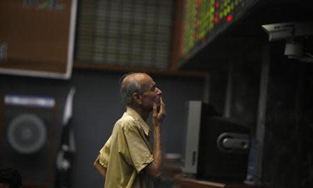 A man reacts as he monitors share prices during a trading session at the Karachi Stock Exchange May 21, 2013. REUTERS/Akhtar Soomro