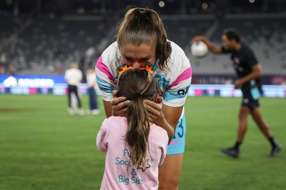 PHOTO: San Diego Wave FC's Alex Morgan kisses her daughter Charlie after the final game of her career on Sept. 8, 2024, in San Diego. (Meg Oliphant/Getty Images)