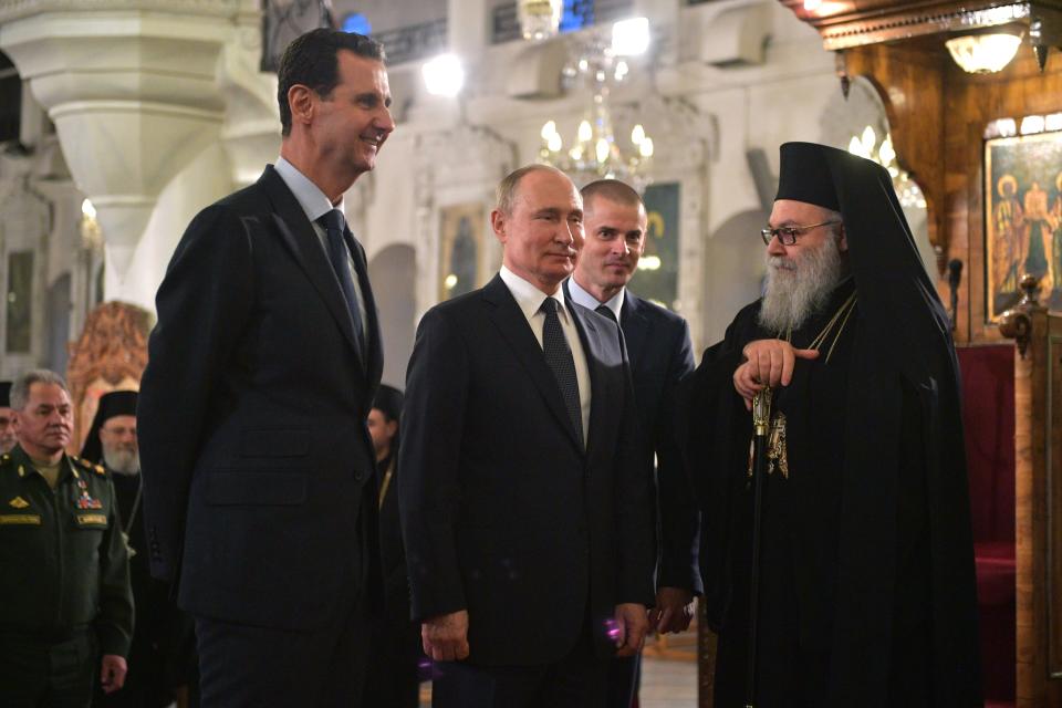 Russian President Vladimir Putin, center, Syrian President Bashar Assad, left, listen to Greek Orthodox Patriarch of Antioch and All the East, right, while visiting an orthodox cathedral for Christmas, in Damascus, Syria, Tuesday, Jan. 7, 2020. Putin has traveled to Syria to meet with President Bashar Assad, a key Iranian ally. The rare visit Tuesday comes amid soaring tensions between Iran and the United States following the U.S. drone strike last week that killed a top Iranian general who led forces supporting Assad in Syria's civil war. (Alexei Druzhinin, Sputnik, Kremlin Pool Photo via AP)