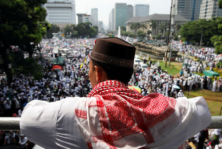 A man watches a rally attended by tens of thousands of Indonesian Muslims to commemorate a series of rallies held in late 2016 targeting the city's former Christian governor Basuki Tjahaja Purnama, in Jakarta, Indonesia December 2, 2018. REUTERS/Darren Whiteside