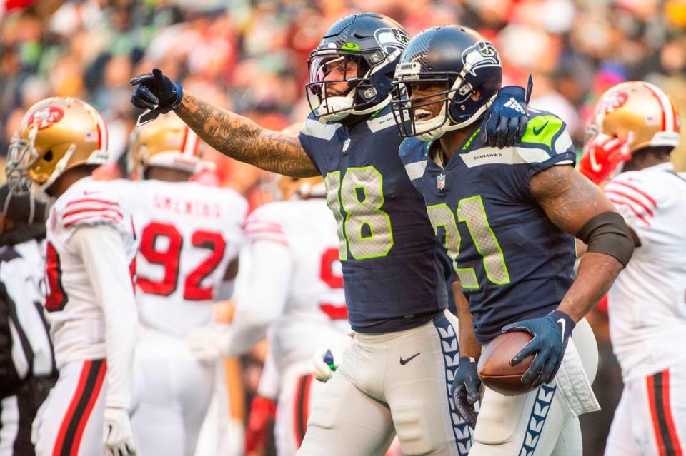 Seattle Seahawks running back Adrian Peterson (21) celebrates with wide receiver Freddie Swain (18) after Peterson scored a touchdown in the second quarter of an NFL game on Sunday at Lumen Field in Seattle.