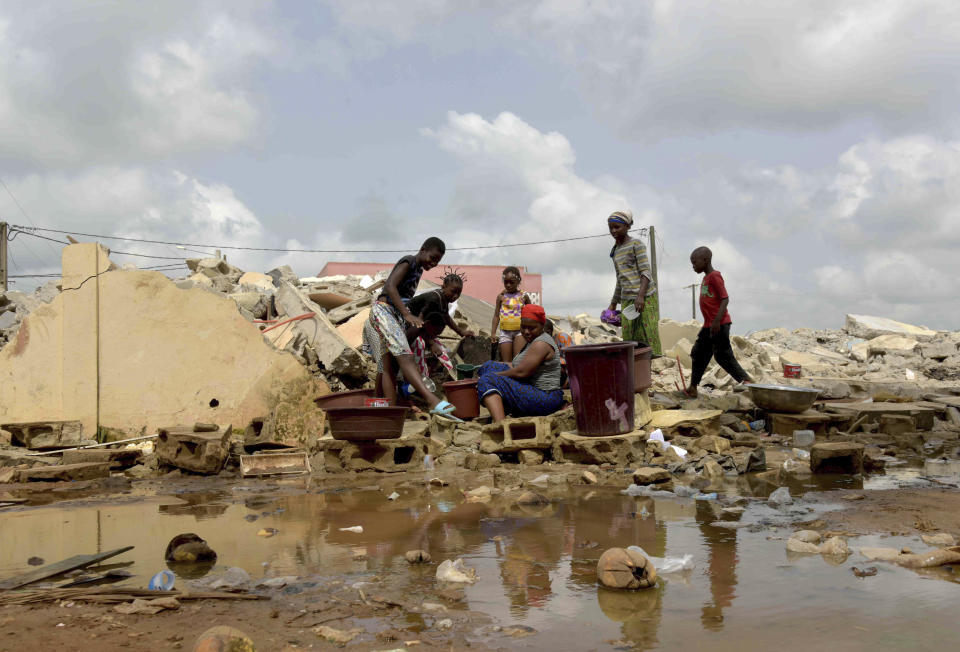 People whose houses were demolished on public health grounds collect water in the Gesco neighborhood of Abidjan, Ivory Coast, Wednesday, Feb. 28, 2024. Rapid urbanisation has led to a population boom and housing shortages in Abidjan, where nearly one in five Ivorians reside, many of them in low-income, crowded communes like the ones in the Gesco and Sebroko districts being demolished on public health grounds. (AP Photo/Diomande Ble Blonde)