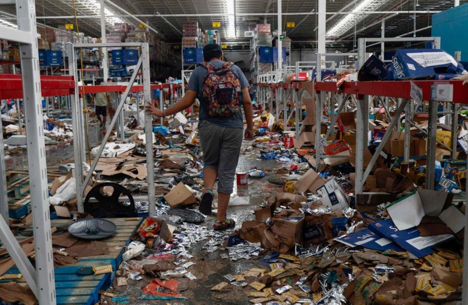 A man walks on a looted supermarket after the passage of Hurricane Otis (AFP via Getty Images)