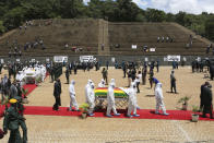 Pallbearers carry the coffin of a government minister of Dr Ellen Gwaradzimba who died of COVID-19, at the Heroes Acre in Harare, Thursday, Jan. 21, 2021. Zimbabwean President Emmerson Mnangagwa who presided over the burial called the pandemic "evil" and urged people to wear masks, practice social distancing and sanitize, as cases across the country increased amid a fragile health system. (AP Photo/Tsvangirayi Mukwazhi)