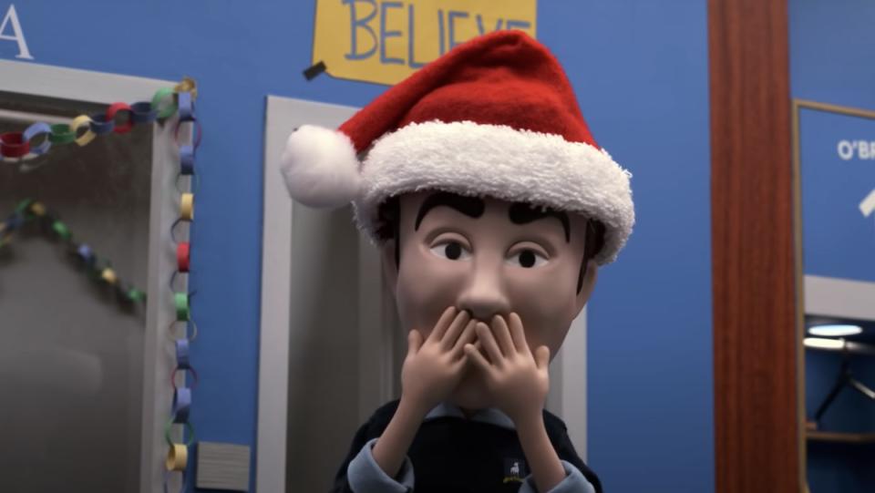 A claymation Ted Lasso in a santa hat holds his face where his mustache is missing