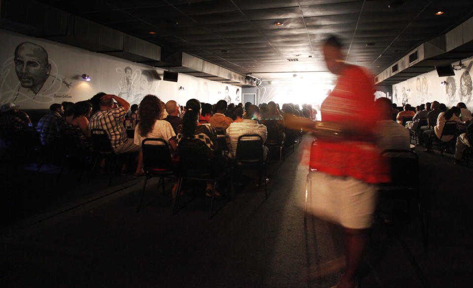 In this June 8, 2012 photo, Mary Lindsey, owner of the Jokes and Notes comedy club is a blur as she moves about the club during the first of two shows in Chicago's Bronzeville neighborhood. African-American female club owners are a rarity in the industry of comedy, but Lindsey is breaking barriers and uplifting a community by providing a place where raw comedic talent can hone their skills. (AP Photo/Charles Rex Arbogast)