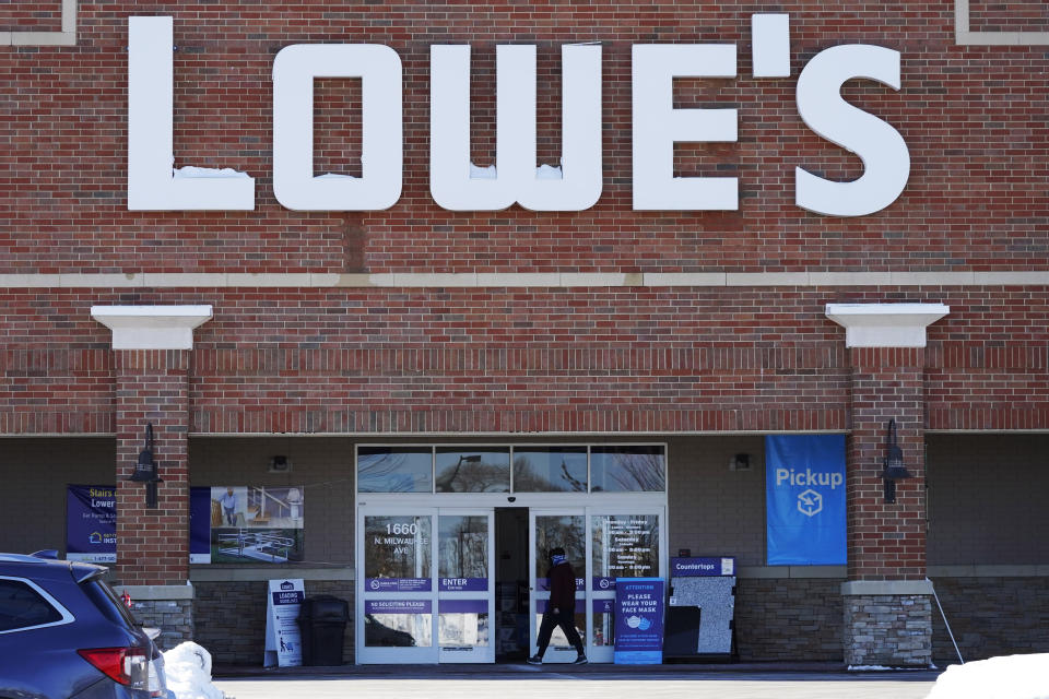 FILE - A customer covers face as he walks to a Lowe's home- improvement store in Vernon Hills, Ill., Wednesday, Feb. 3, 2021. Companies that would be affected by a Biden administration vaccine-or-testing requirement for workers remain on the sidelines while the Supreme Court considers whether the rule can be enforced. Many companies including Lowe's and Target have publicly said they would abide by any federal vaccine mandate and were taking steps to meet the mandate, but stopped short of coming out with their own requirement. (AP Photo/Nam Y. Huh, File)