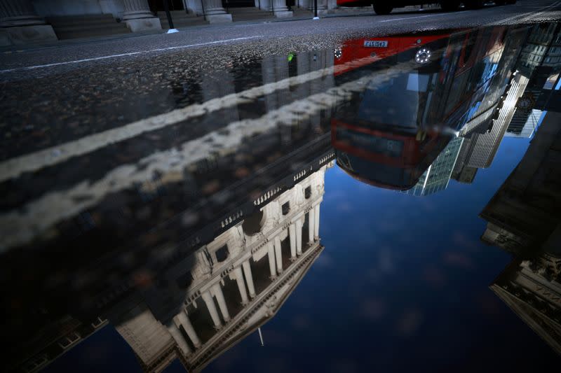 FILE PHOTO: The Bank of England and the City of London financial district are reflected in a puddle, in London