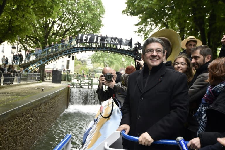 French presidential election candidate for the far-left coalition La France insoumise Jean-Luc Melenchon (L), stands aboard an "unbowed" barge on the Canal Saint-Martin on April 17, 2017 in Paris